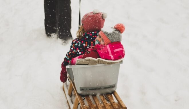 Baby dressed in warm layers for mountain weather in Whistler on a Sled